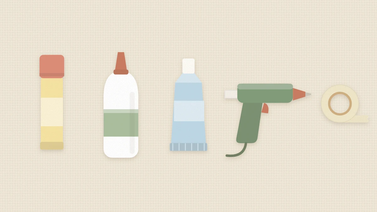 Glue stick, white craft glue, tacky glue tube, hot glue gun and double-sided tape lined up on a table