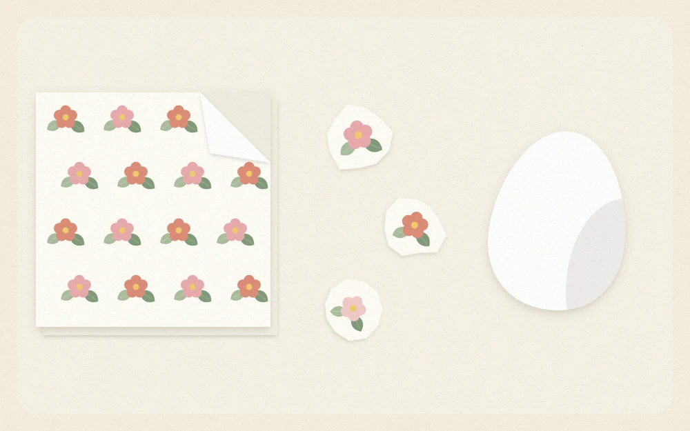 Floral paper napkin with its top ply peeled back and torn flower motifs beside a plain white egg