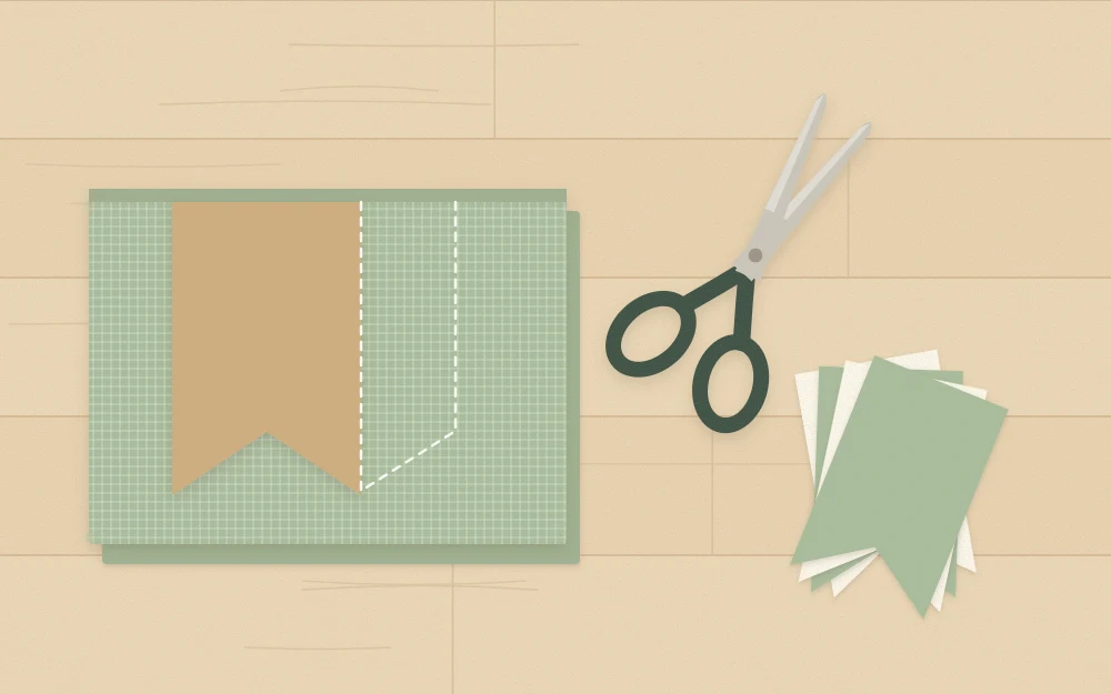 A cardboard pennant template on folded fabric with fabric scissors and a stack of cut pennants