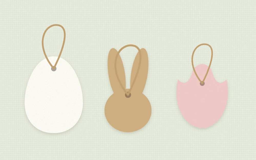 Blank cardstock gift tags in egg, bunny head and tulip shapes with punched holes and twine loops