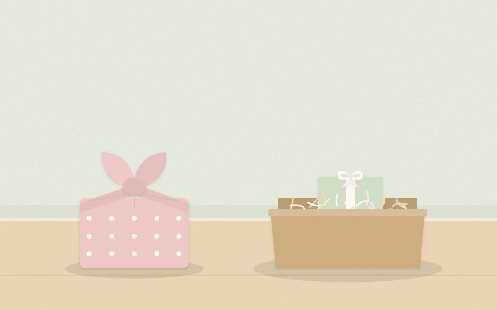 Small box wrapped in knotted fabric beside another small box nested in paper shred