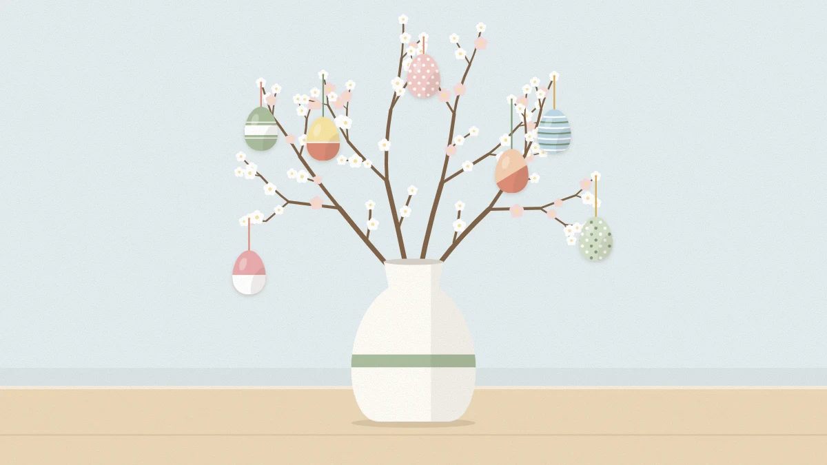 Bare flowering branches in a ceramic vase with pastel eggs hanging from the twigs on thin ribbons