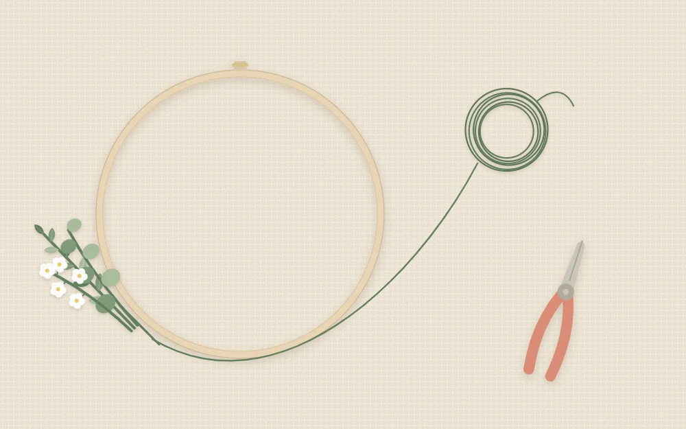 Bare wooden hoop with a small bundle of stems being wired on, floral wire and cutters beside it