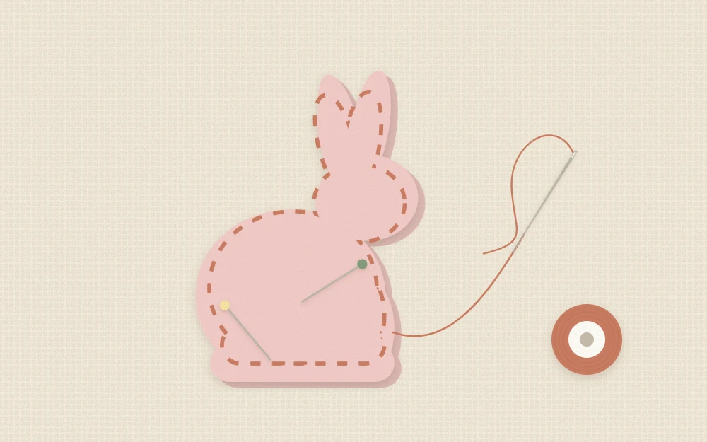 Two matching felt bunny shapes pinned together with a needle making a running stitch around the edge