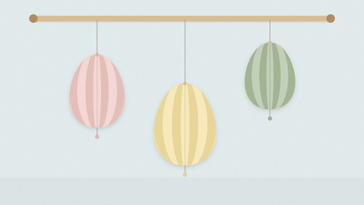 Three finished 3D paper eggs in pastel cardstock hanging from threads at different heights