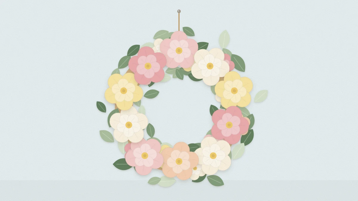 A wreath of layered paper flowers in blush, cream and soft yellow with sage paper leaves on a wall